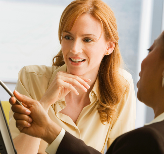 Close crop of a woman talking to advisor who is gesturing with a stylus.